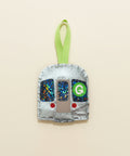 Decorative ornament shaped like a train car with a green 'G' on a wooden surface