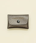 Silver textured wallet with a button on a wooden surface