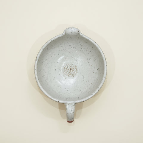 Interior shot of a the speckled white ceramic salad dressing bowl