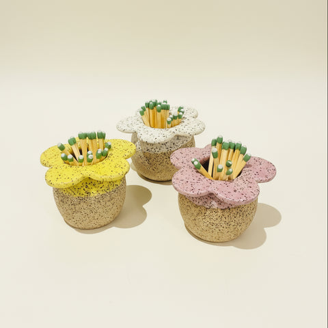 Three flower-shaped ceramic matchboxes with matches