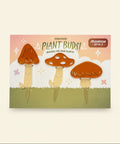 Set of three mushroom-shaped planters on a decorative card with 'Plant Buds!' branding on a wooden surface.