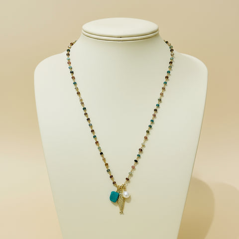 Necklace with beads and charms on a wooden surface