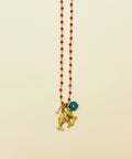Necklace with gold pendants and red beads on a wooden surface