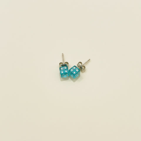 Pair of dice-shaped earrings on a wooden surface