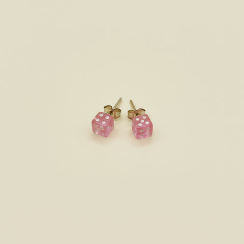 Pink square earrings on a wooden surface