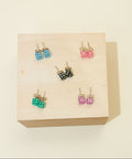 Set of colorful earrings on a wooden display box