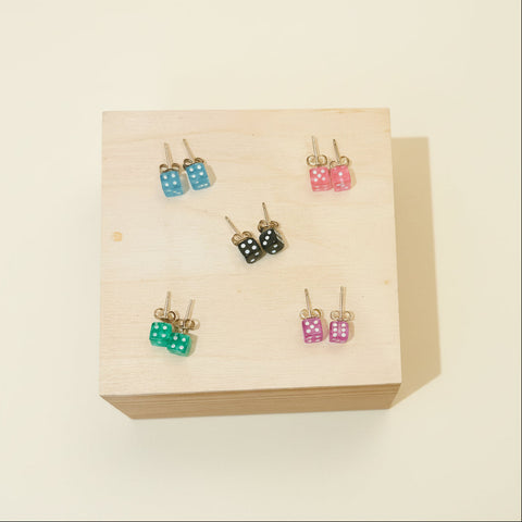 Set of colorful earrings on a wooden display box