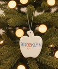 Ceramic apple-shaped ornament hanging on a christmas tree