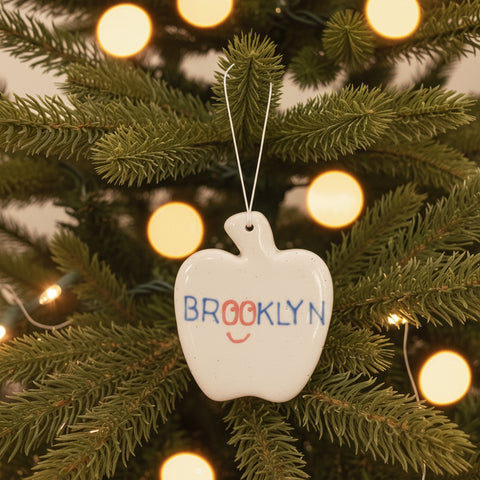 Ceramic apple-shaped ornament hanging on a christmas tree
