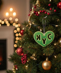 Green heart-shaped ornament with 'NYC' cutout on a wooden surface
