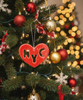 Red heart-shaped ornament with 'NYC' cutout on a wooden surface