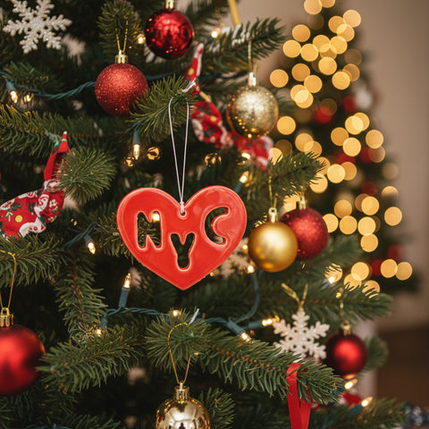 Red heart-shaped ornament with 'NYC' cutout on a wooden surface
