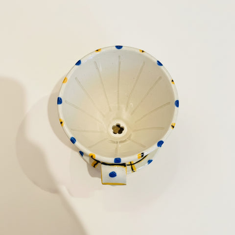 White funnel with blue and yellow accents on a wooden surface