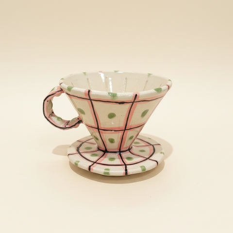 Ceramic coffee filter with polka dot design on a wooden surface