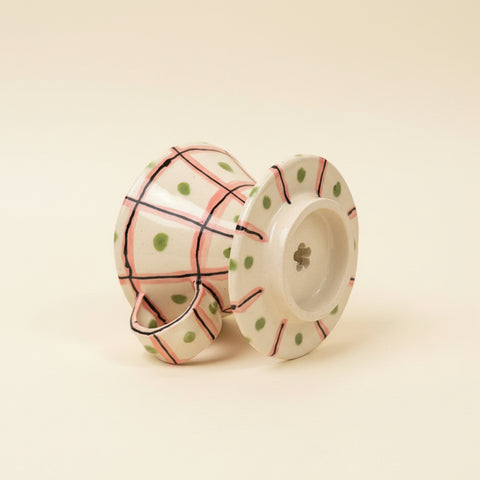 Decorative ceramic pour over cup with polka dot pattern on a wooden surface.