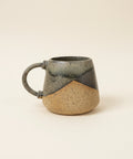 Ceramic mug on a wooden table with a blurred office background