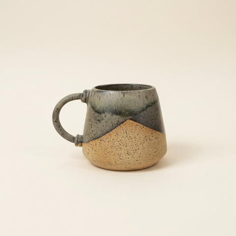 Ceramic mug on a wooden table with a blurred office background