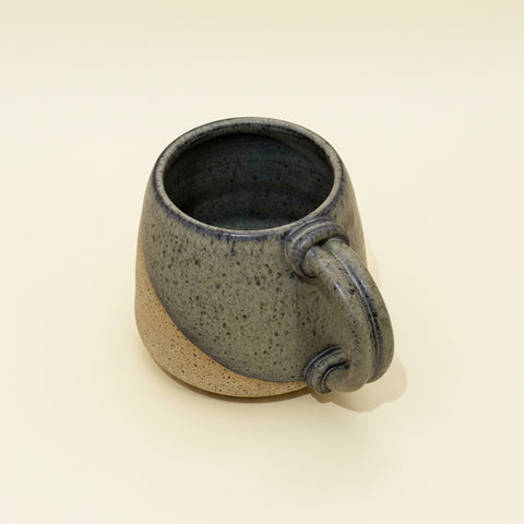 Speckled gray ceramic mug on a wooden surface
