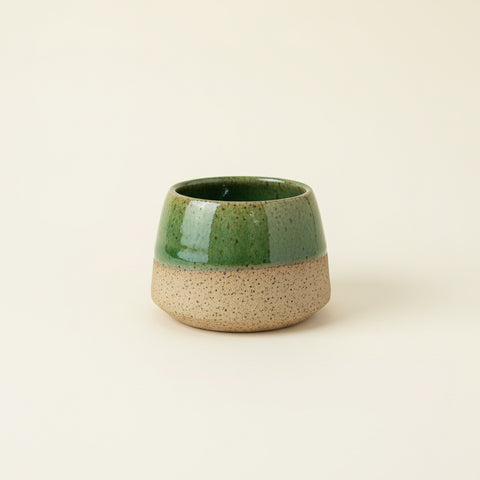 Green ceramic cup on a wooden surface