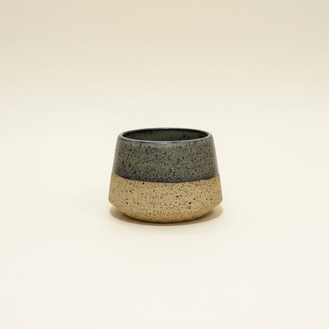 Ceramic container with two-tone design on a wooden surface