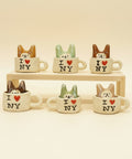 Set of small ceramic mugs with cat designs and 'I ❤️ NY' text on a wooden surface.