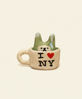 Small ceramic cup with a bear design and 'I ❤️ NY' text on a wooden surface.
