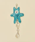 Blue star-shaped hanging ornament with decorative elements on a wooden surface