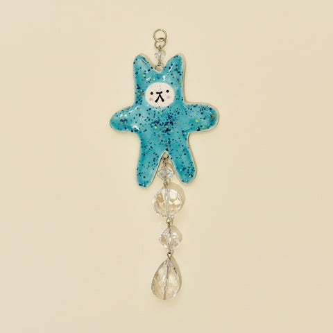 Blue star-shaped hanging ornament with decorative elements on a wooden surface