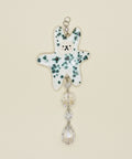 Decorative hanging charm with a polka dot design on a wooden surface