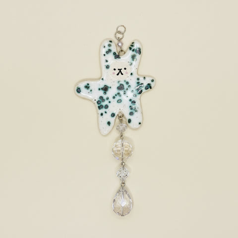 Decorative hanging charm with a polka dot design on a wooden surface