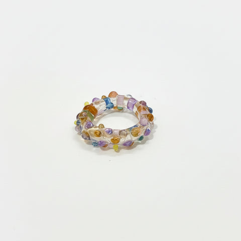 Multicolored beaded ring on a wooden surface