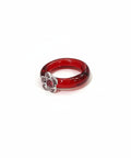 Red glass ring with a decorative element on a wooden surface