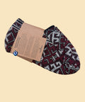 Pair of patterned socks with a brand tag on a wooden surface, next to a person wearing the socks.
