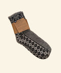 Black and gray patterned sock on a wooden desk next to a laptop