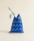 Blue fish-shaped object on a wooden surface with blurred office background