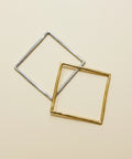 Two square-shaped metal frames on a wooden surface