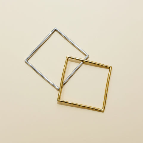 Two square-shaped metal frames on a wooden surface