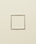 Silver square ring on a wooden surface