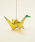 stained glass sun catcher shaped like a paper crane.