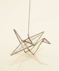 stained glass sun catcher shaped like a paper crane with multi color wings and a pink head.