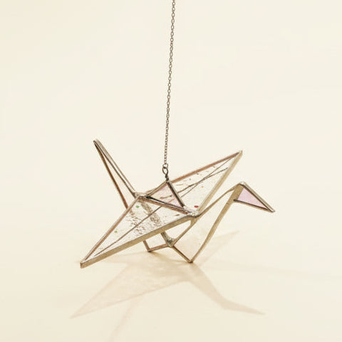 stained glass sun catcher shaped like a paper crane with multi color wings and a pink head.