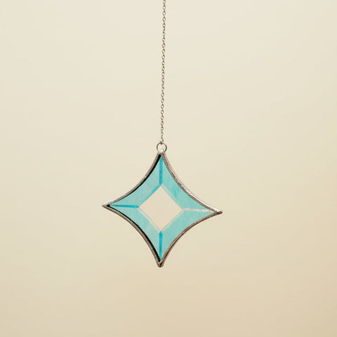 Decorative star-shaped object with a blue pattern on a beige wall