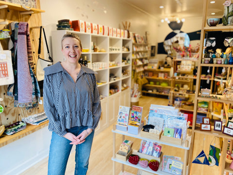 Woman standing in a store with shelves and products in the background
