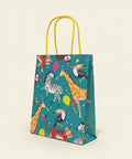Colorful gift bag with animal patterns hanging on a wooden surface.