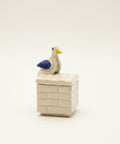 ceramic trinket box with a ceramic pigeon on it.