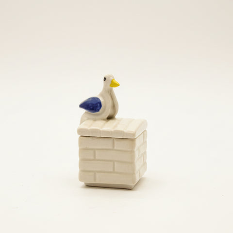 ceramic trinket box with a ceramic pigeon on it.