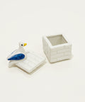 Small ceramic trinket box with a pigeon figurine attached to the top.