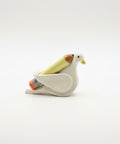 Decorative bird-shaped sculpture holding a sculpted pencil