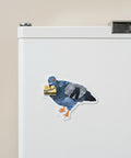 A die-cut sticker featuring a stylized pigeon collage made from blue denim, black-and-white newspaper print, and an orange beak and feet, holding a yellow Metrocard, shown on a plain light beige background.