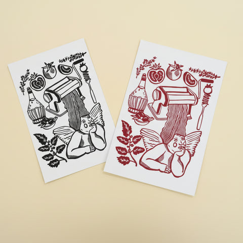 Two sheets of paper with black and red illustrations on a wooden surface